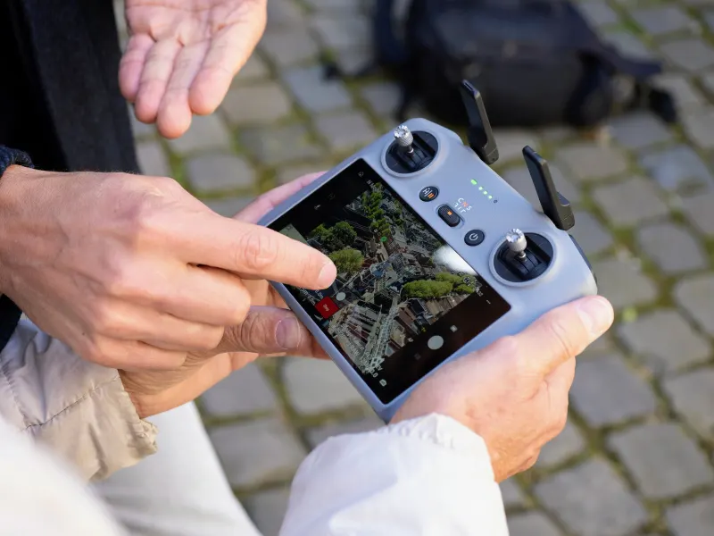 DJI controller met live beeld van de binnenstad, de docent wijst een instelling aan
