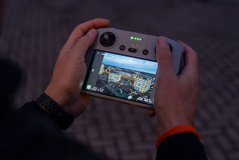 DJI controller met live beeld van de stad in de schemering