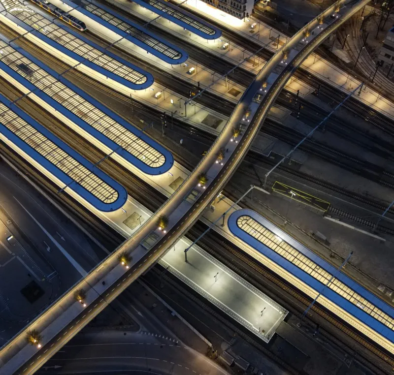 Perronkappen en een loopbrug van een station bij avond, van boven