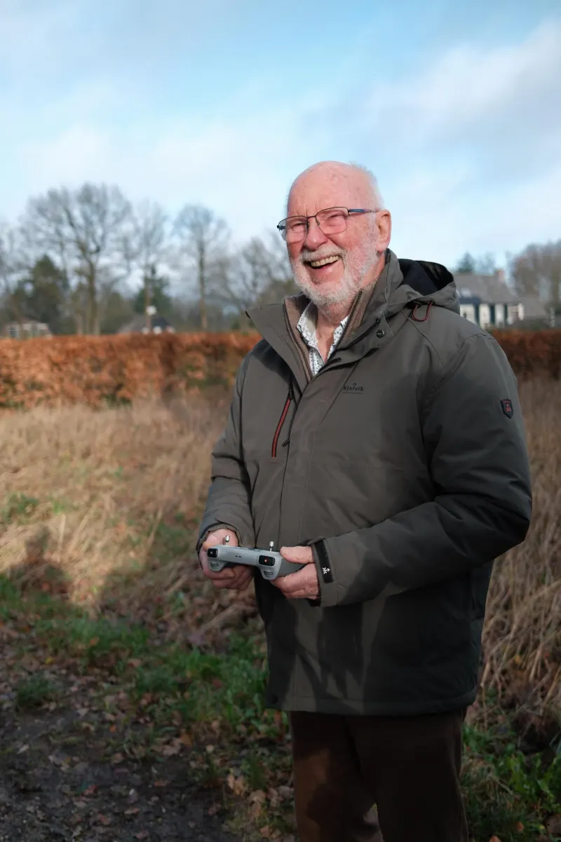 Deelnemer van 80 met de controller in handen tijdens de workshop dronevliegen