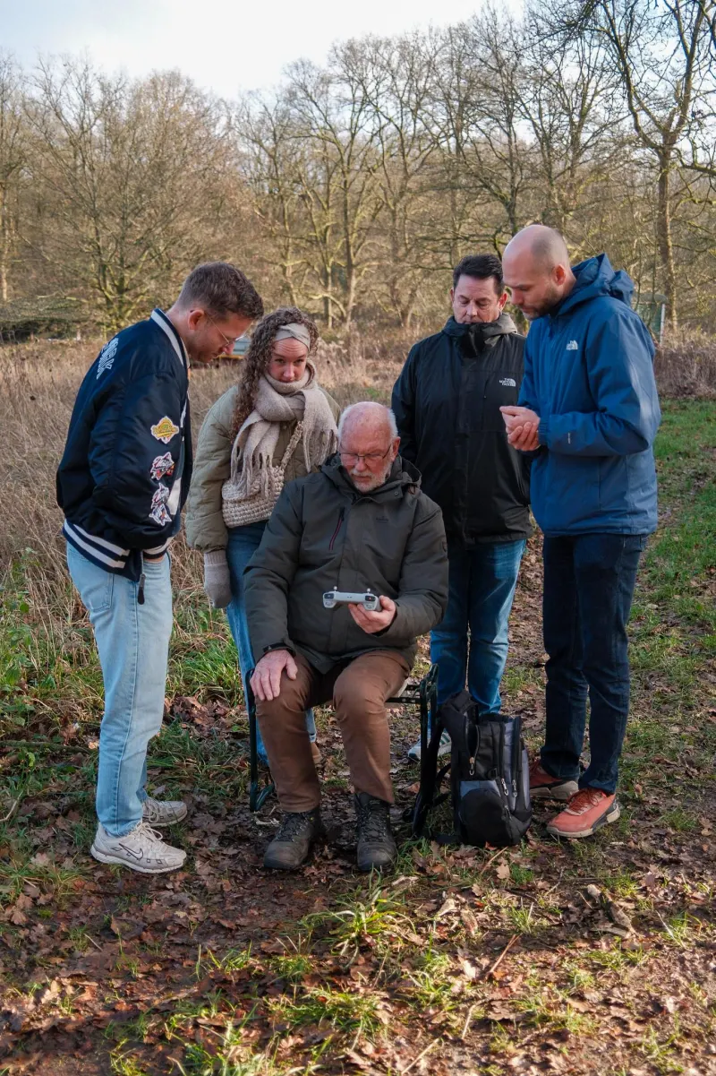 Groep van 4 rond de controller tijdens een workshop dronevliegen